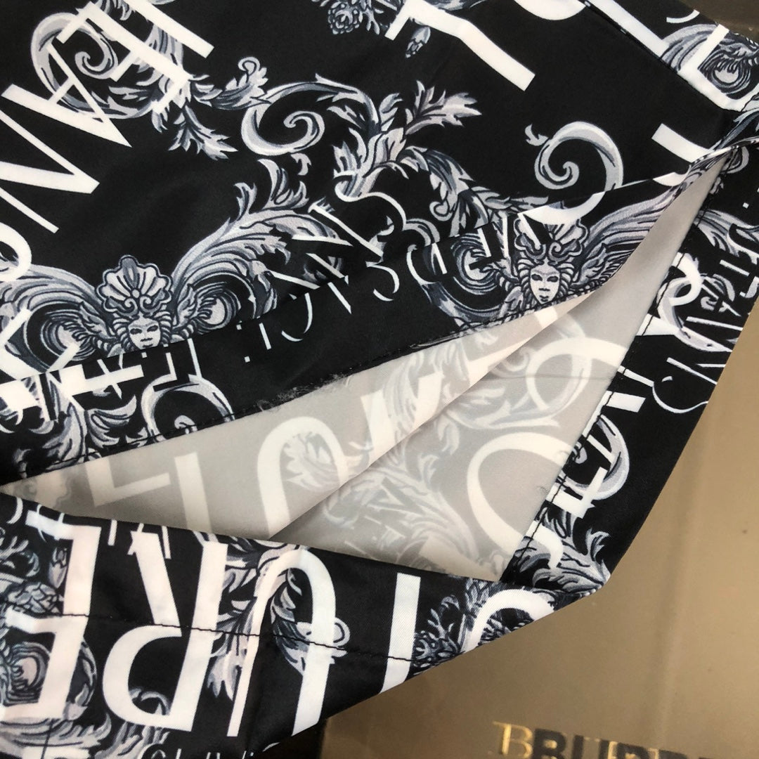 Versace shorts hem detail with black-and-white baroque style graphic print.