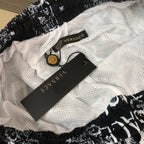 Versace shorts with white mesh lining and black elastic waistband, showing label.