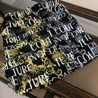 Patterned shorts, black with gold and white ornate text-style print, front view