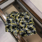 Versace patterned shorts, black with gold and white repeat graphic, side view