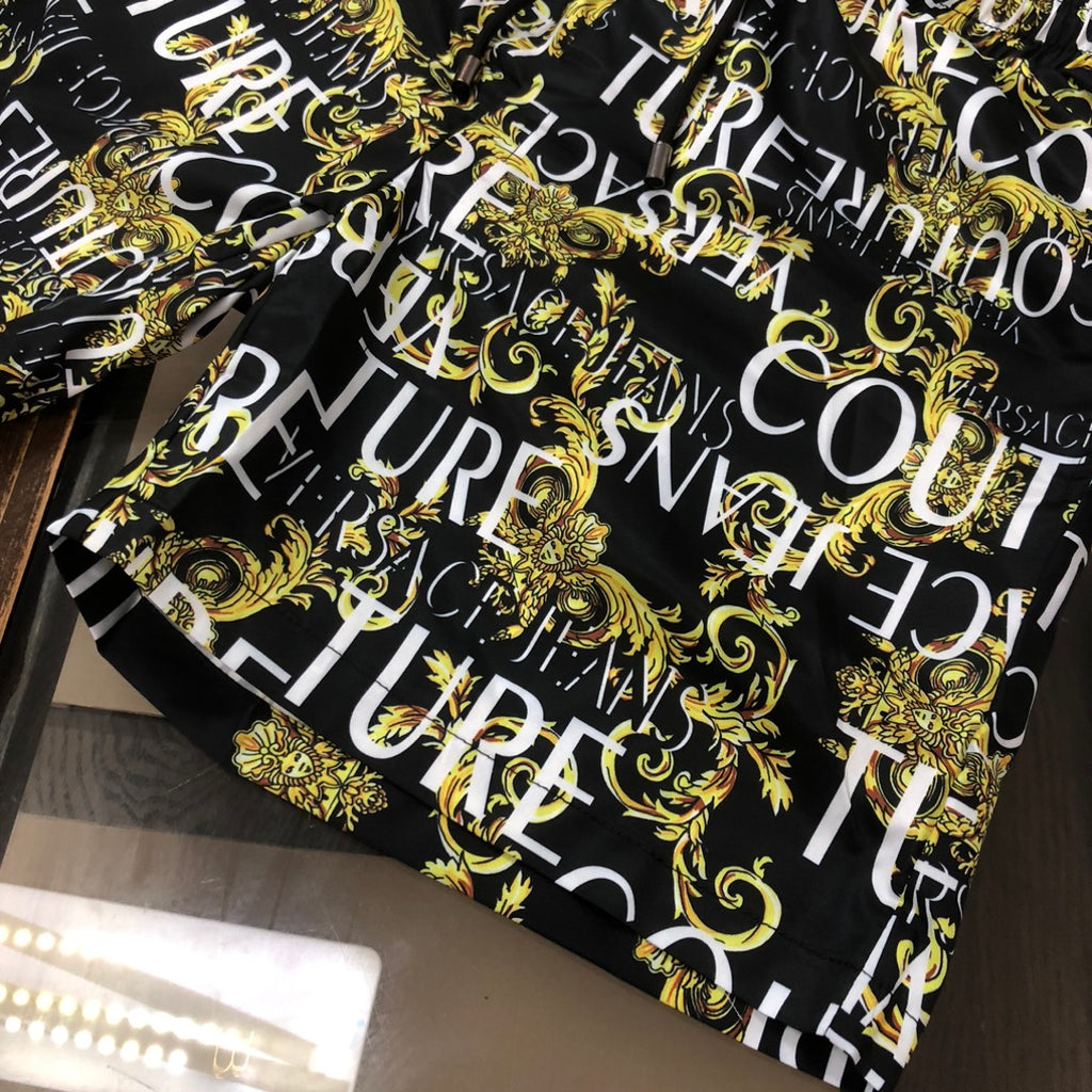 Patterned shorts, black with gold baroque swirls and large white letter print
