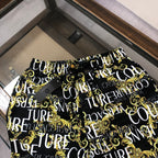 Versace patterned shorts, black with gold and white repeat pattern, buttoned fly