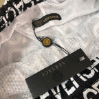 Versace logo shorts with white mesh panel, black care label, and small tag