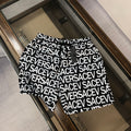 Versace logo shorts in black with white repeating text pattern