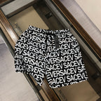 Versace logo shorts in black with white repeating text pattern