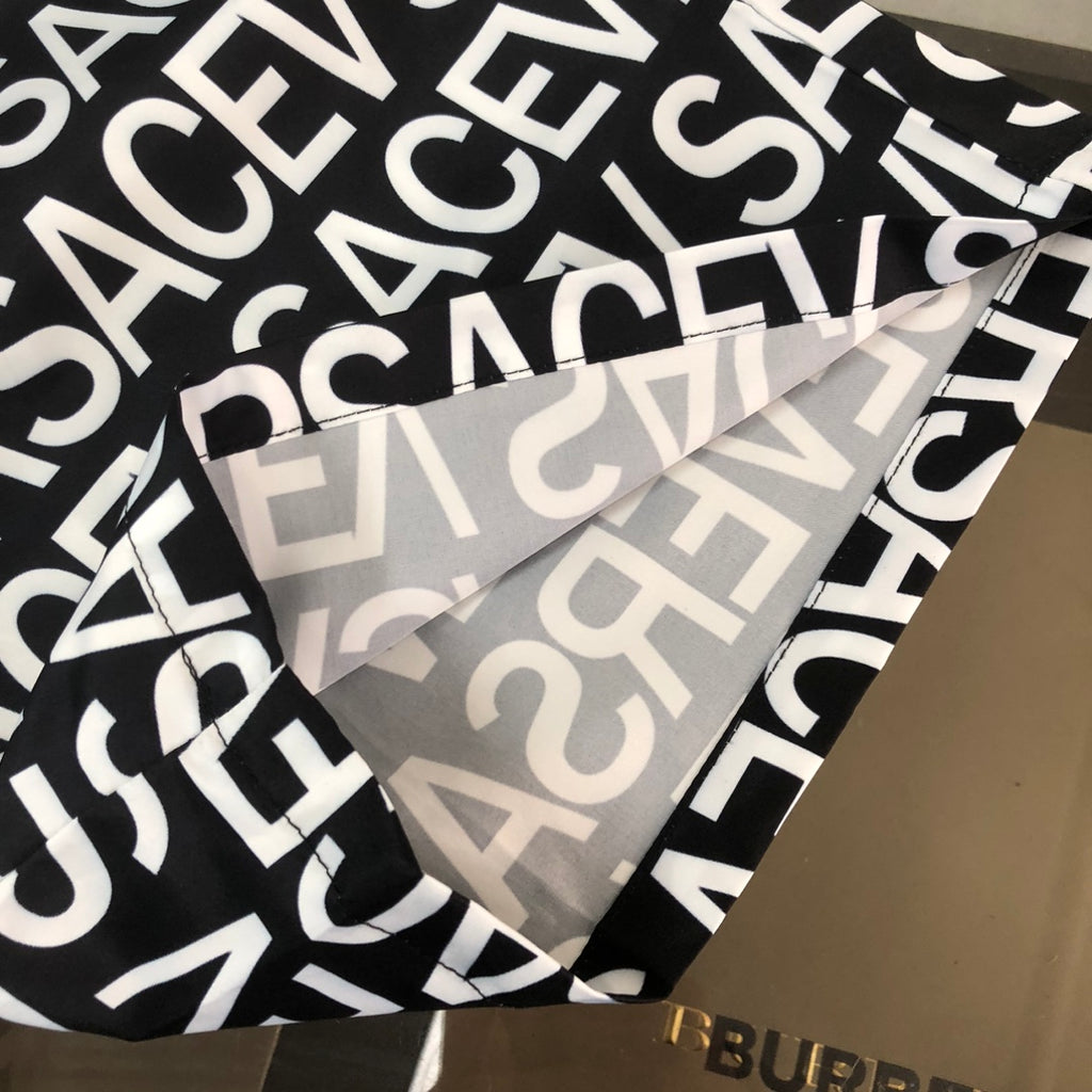Versace logo shorts fabric close-up with bold white letters on black