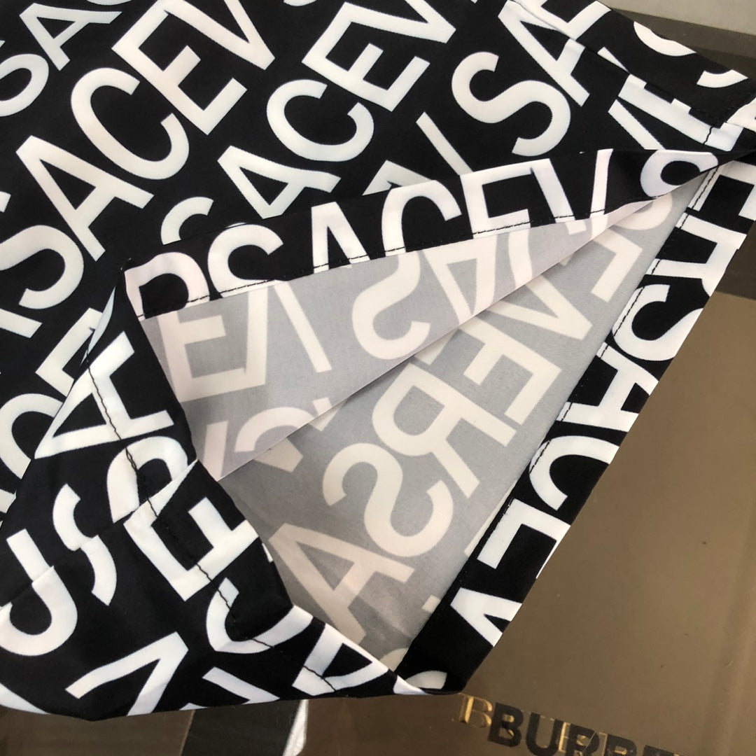 Versace logo shorts fabric close-up with bold white letters on black