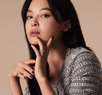 Gold-tone ring with stone bezel detail on finger, shown with bracelets and earrings