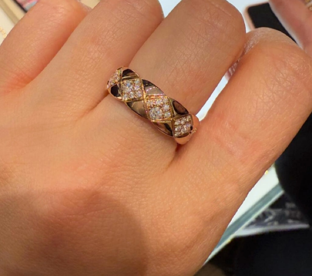 Gold-tone wide ring with faceted stone pattern, worn on an open palm