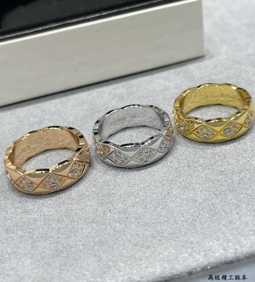 Three wide rings with diamond-like stone insets in gold and silver tones
