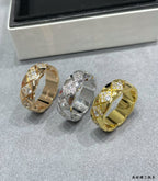 Three wide rings with faceted stone details, gold-tone and silver-tone