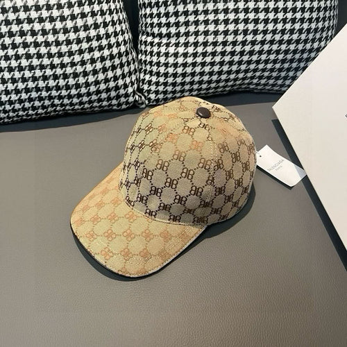 Tan monogram baseball cap with black brim and front button detail.