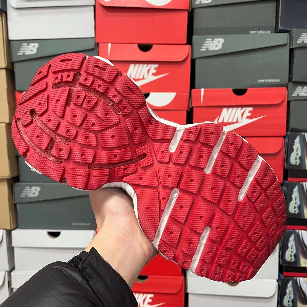 Unisex sneakers outsole view with red rubber tread and gray side edges