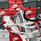 Unisex sneakers front-left view with black tongue, white knit upper, and red outsole