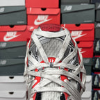Unisex sneakers front view with white knit upper, gray laces, and red heel details