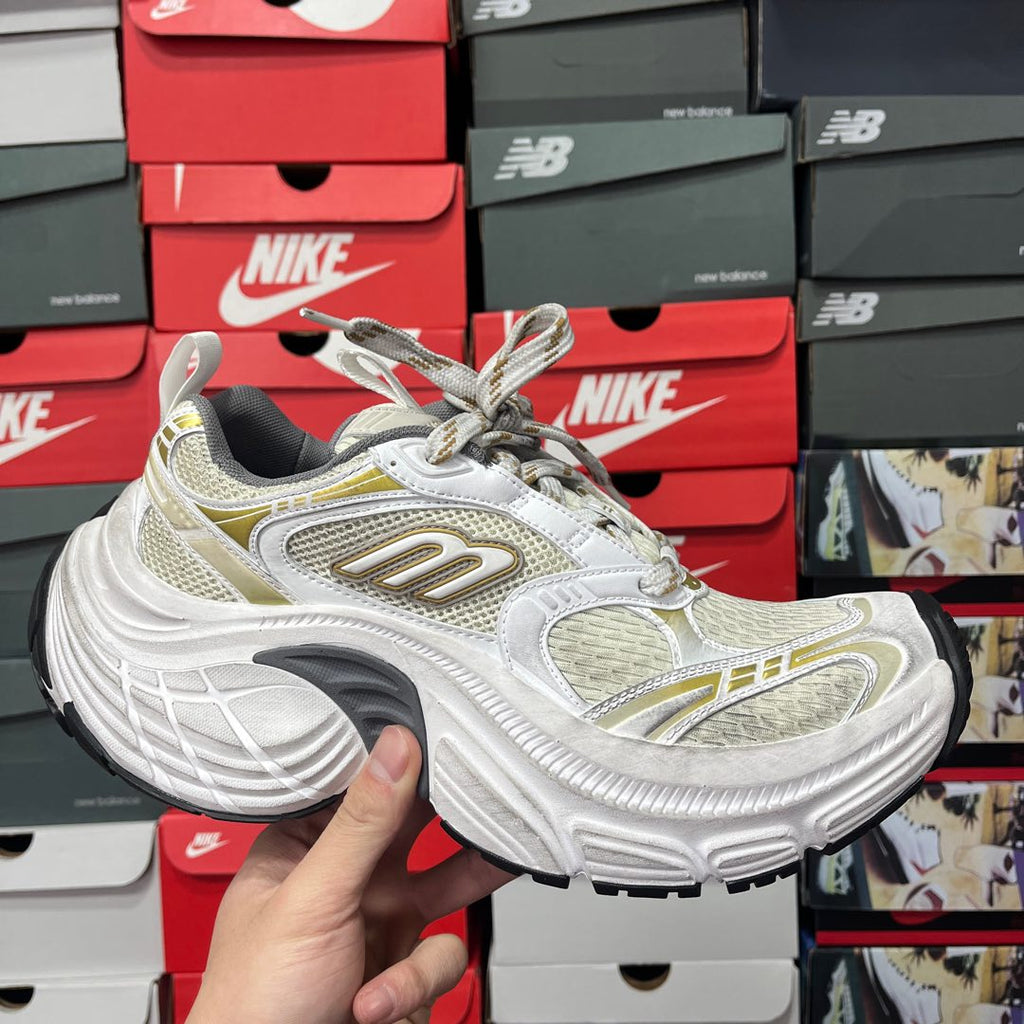 White and light-yellow lace-up sneaker with gold side logo accents and mesh upper