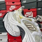White and light-yellow mesh sneaker with gold trim, lace-up eyelets, and thick sole