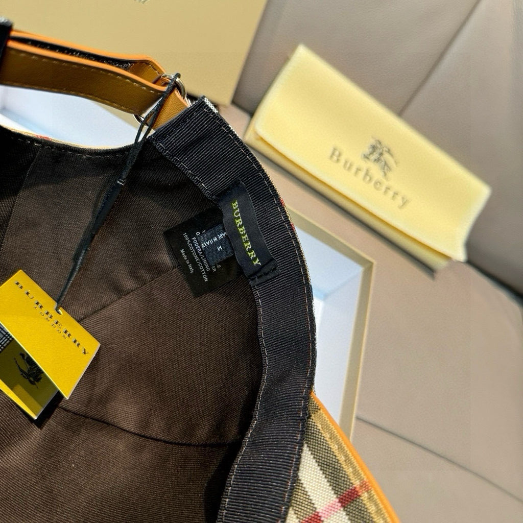 Brown fabric cap with black strap and tag; interior with contrasting check lining.