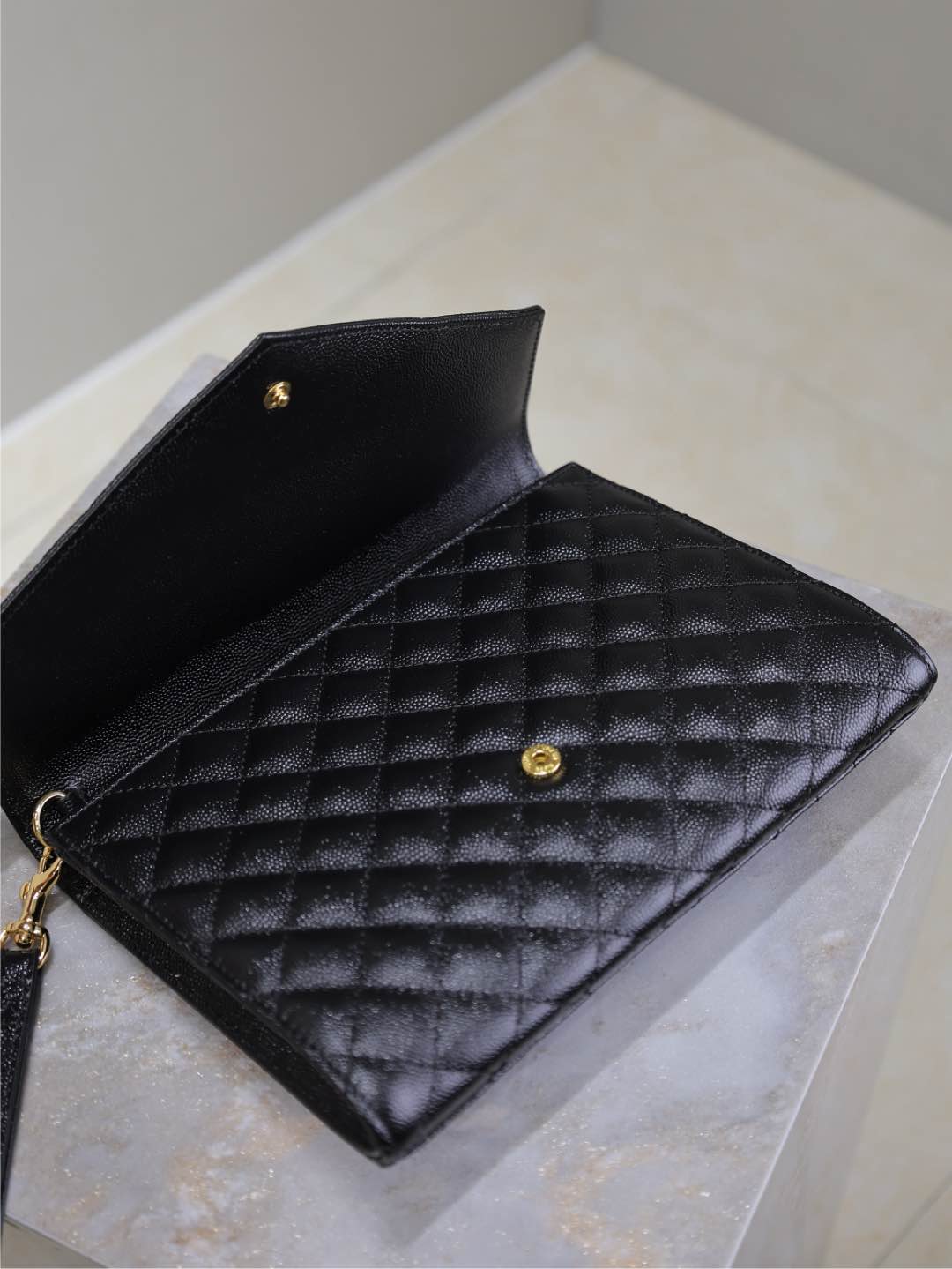 YSL small black quilted leather bag with open flap, gold hardware, and interior.