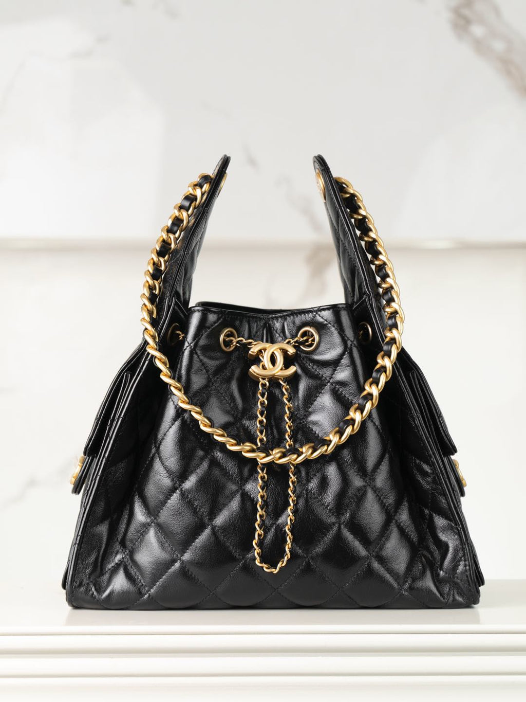 Chanel quilted black leather mini bag with gold chain handles and tassel detail