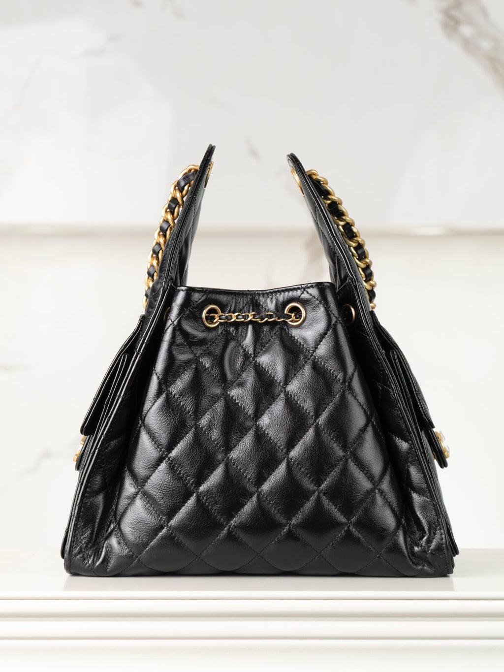 Chanel black quilted leather triangle bag with gold chain trim and side tassels