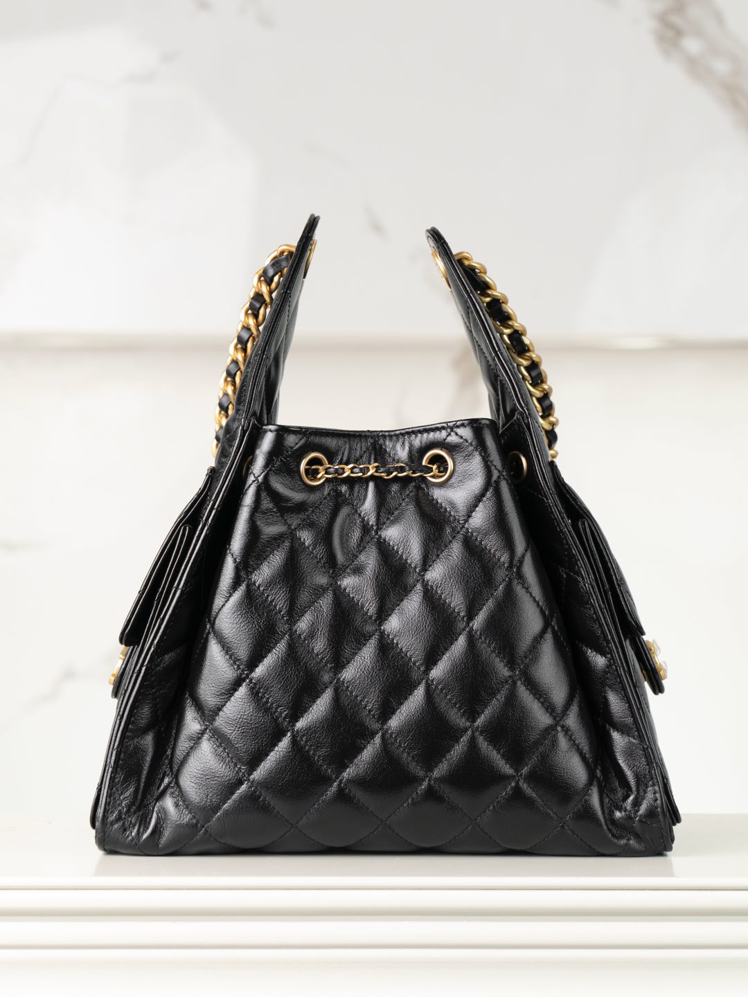 Chanel black quilted leather triangle bag with gold chain trim and side tassels