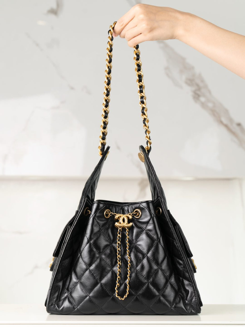 Chanel black quilted leather bucket bag with gold chain handles and CC clasp