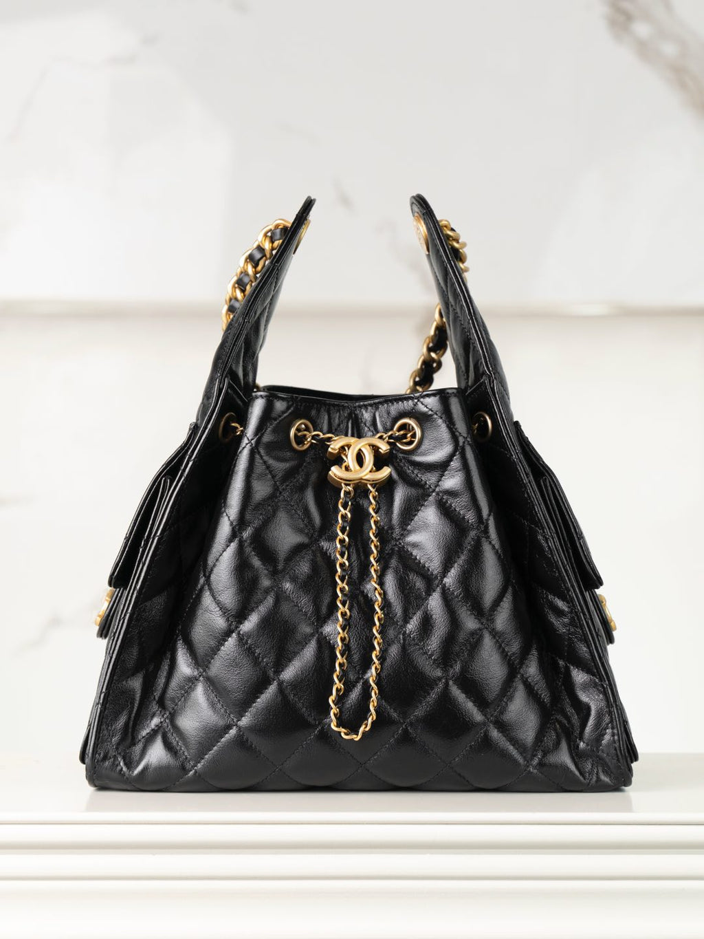 Chanel black quilted leather bucket bag with gold chain handles and CC clasp
