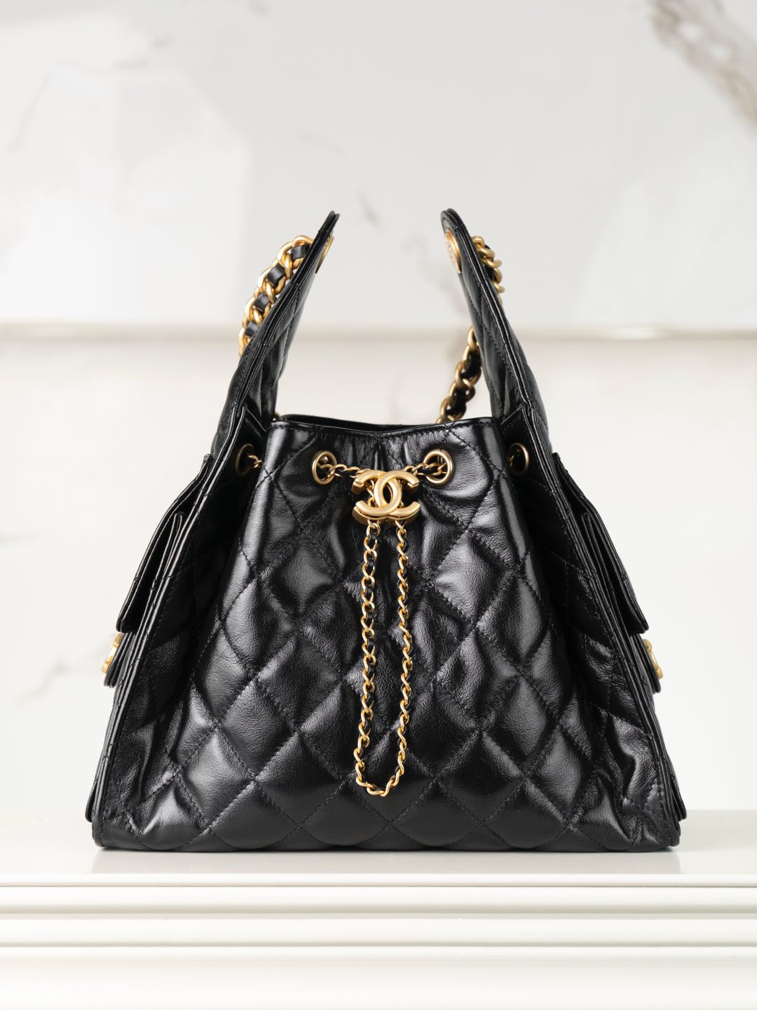 Chanel black quilted leather bucket bag with gold chain handles and CC clasp