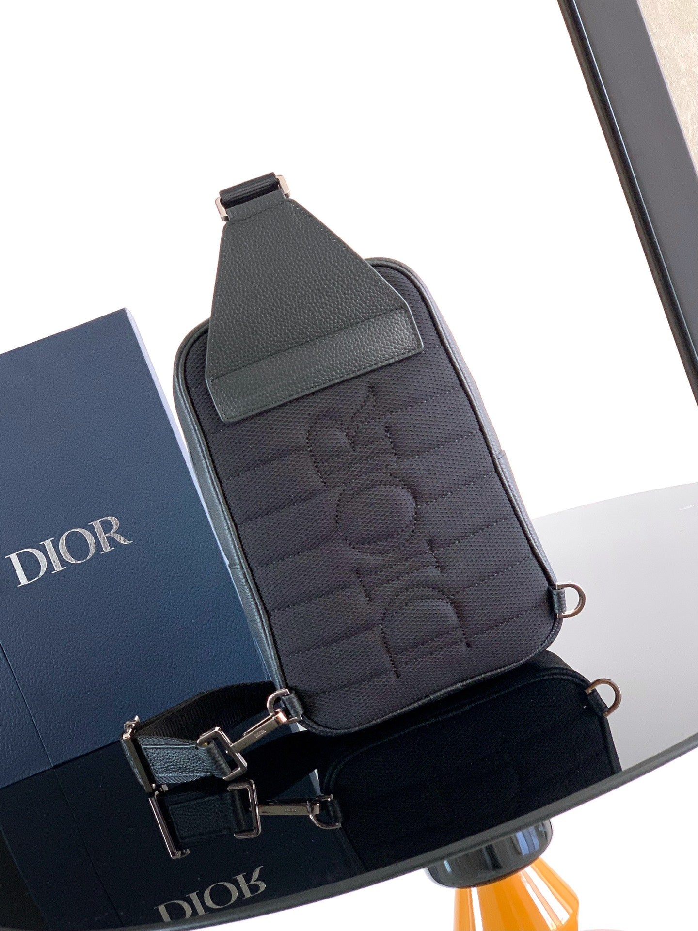 Dior mini crossbody bag in dark leather with embossed monogram pattern and top handle