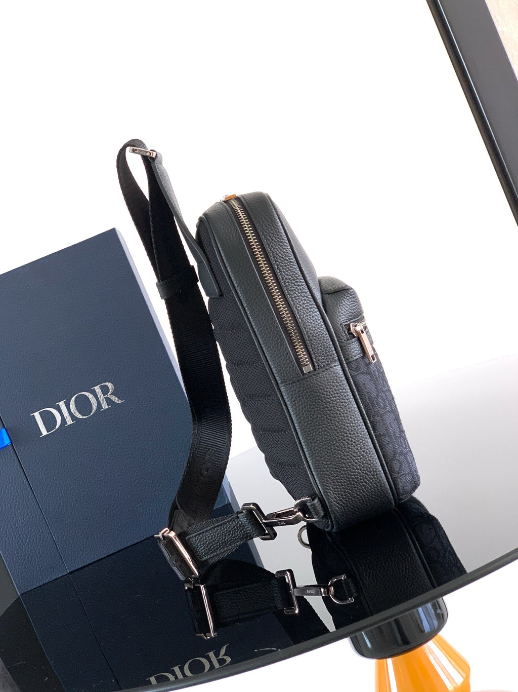 Dior mini crossbody bag side view with silver-tone buckle hardware and top zip
