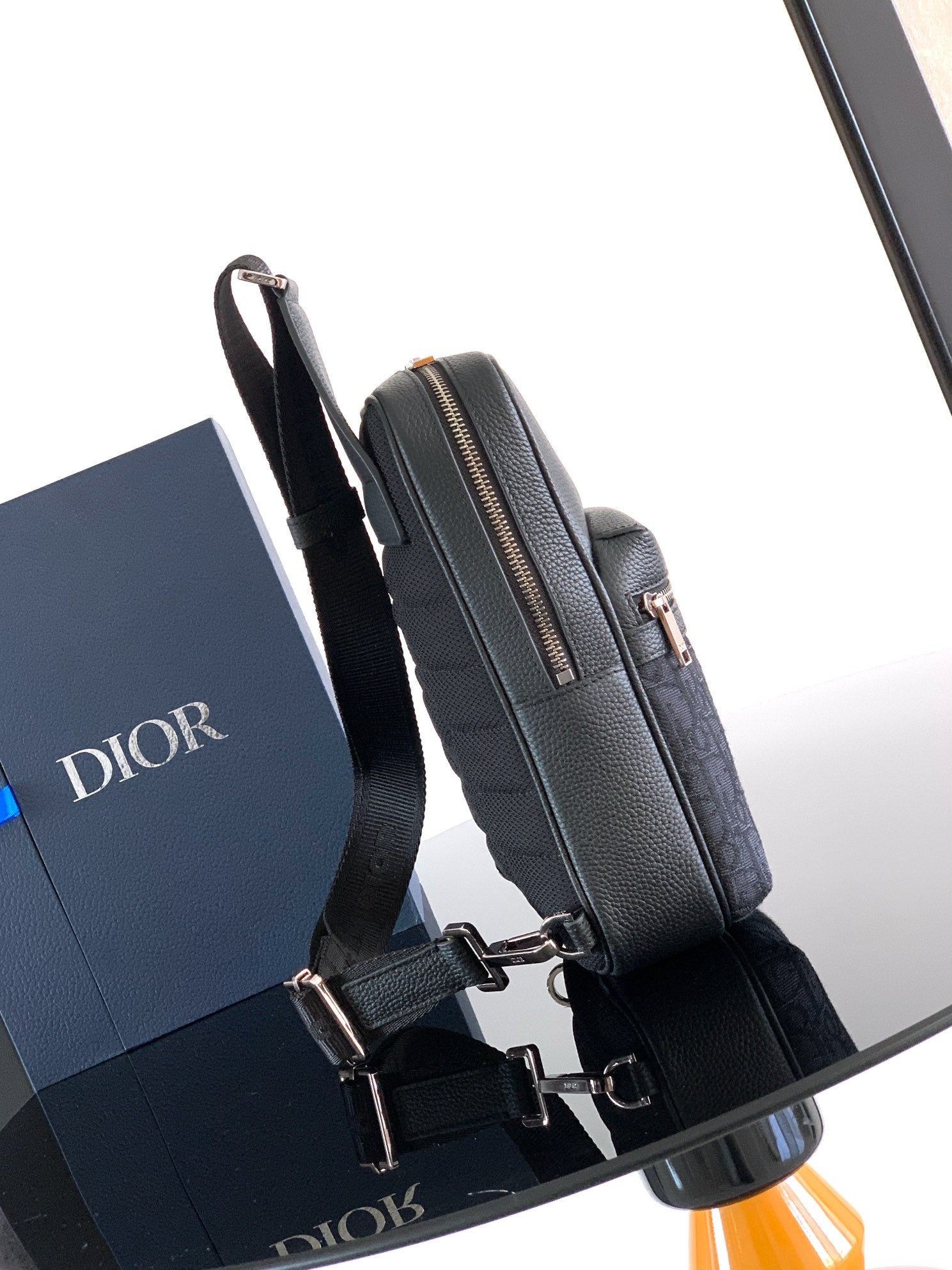 Dior mini crossbody bag side view with silver-tone buckle hardware and top zip