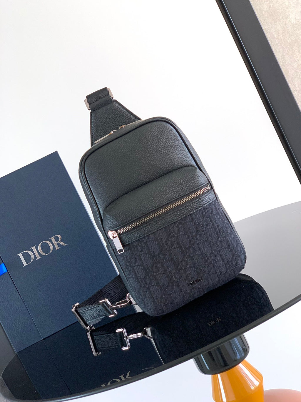 Dior mini crossbody bag in dark textured leather with front zip pocket and strap