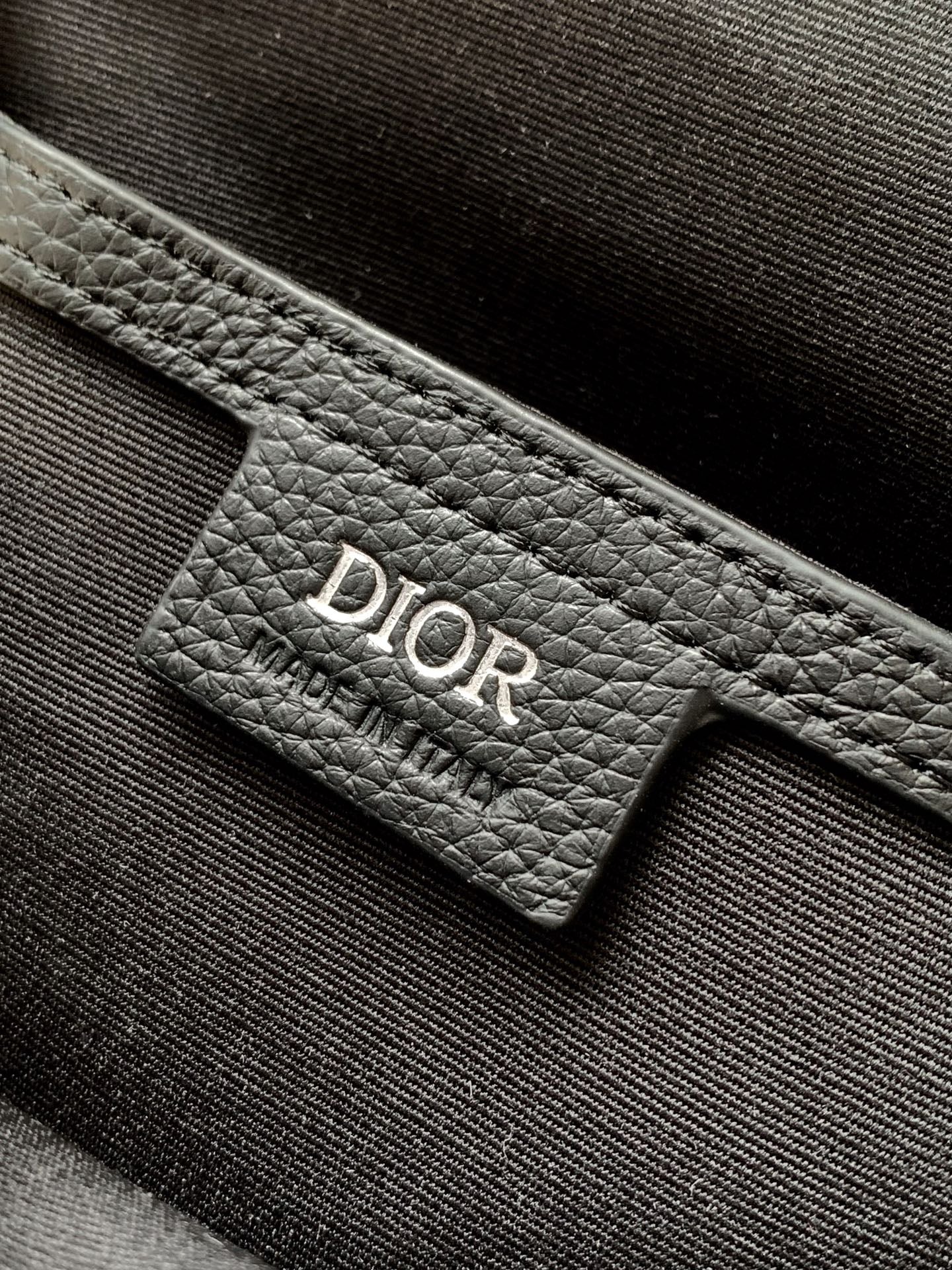 Dior mini crossbody bag interior tag with Dior logo on dark leather lining