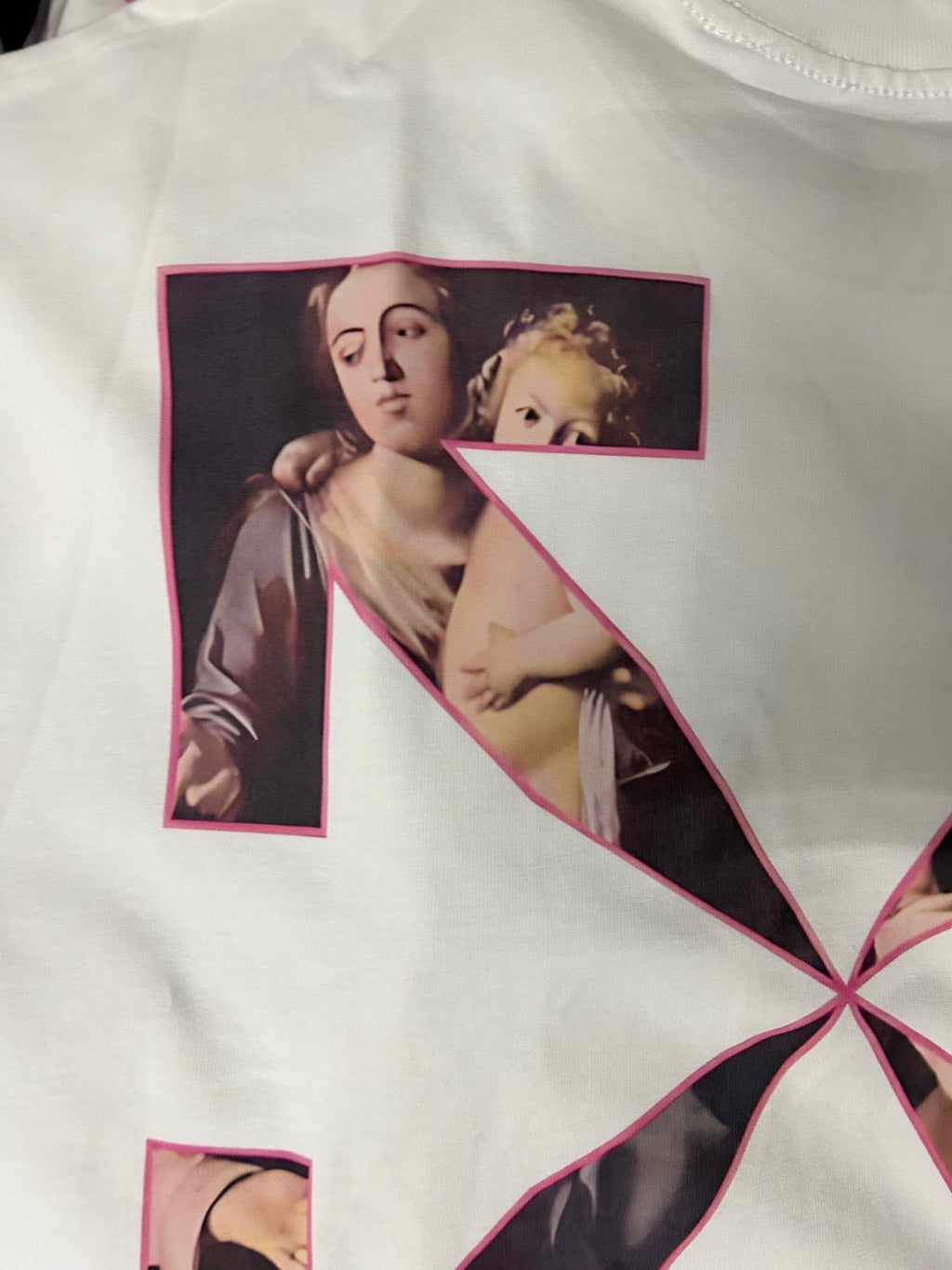 Graphic T-shirt with pink-outlined portrait collage forming a letter on the front