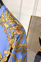 Side view of light blue crewneck T-shirt with blue and gold baroque sleeve pattern