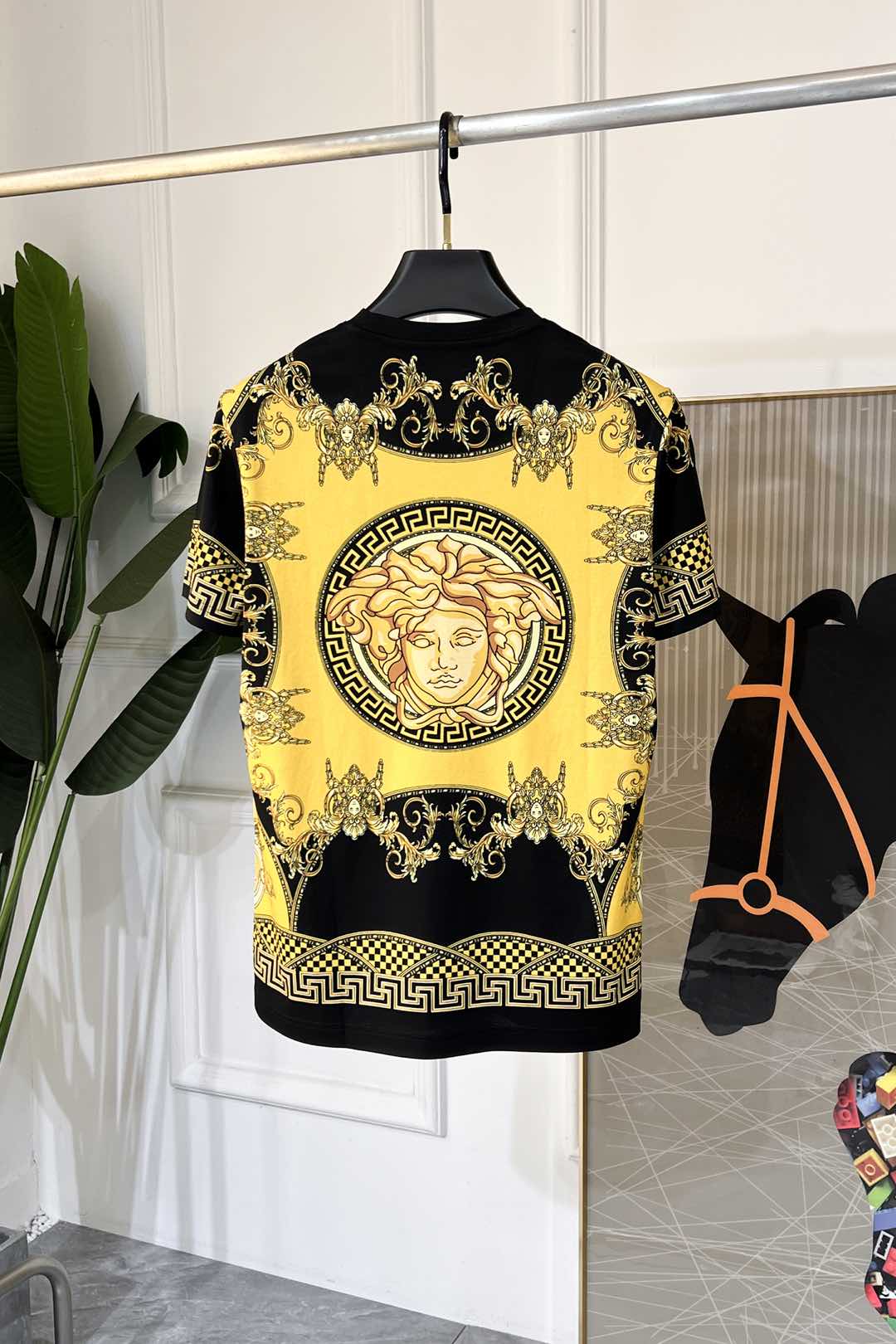 Short-sleeve graphic T-shirt in black with large yellow Medusa-style motif