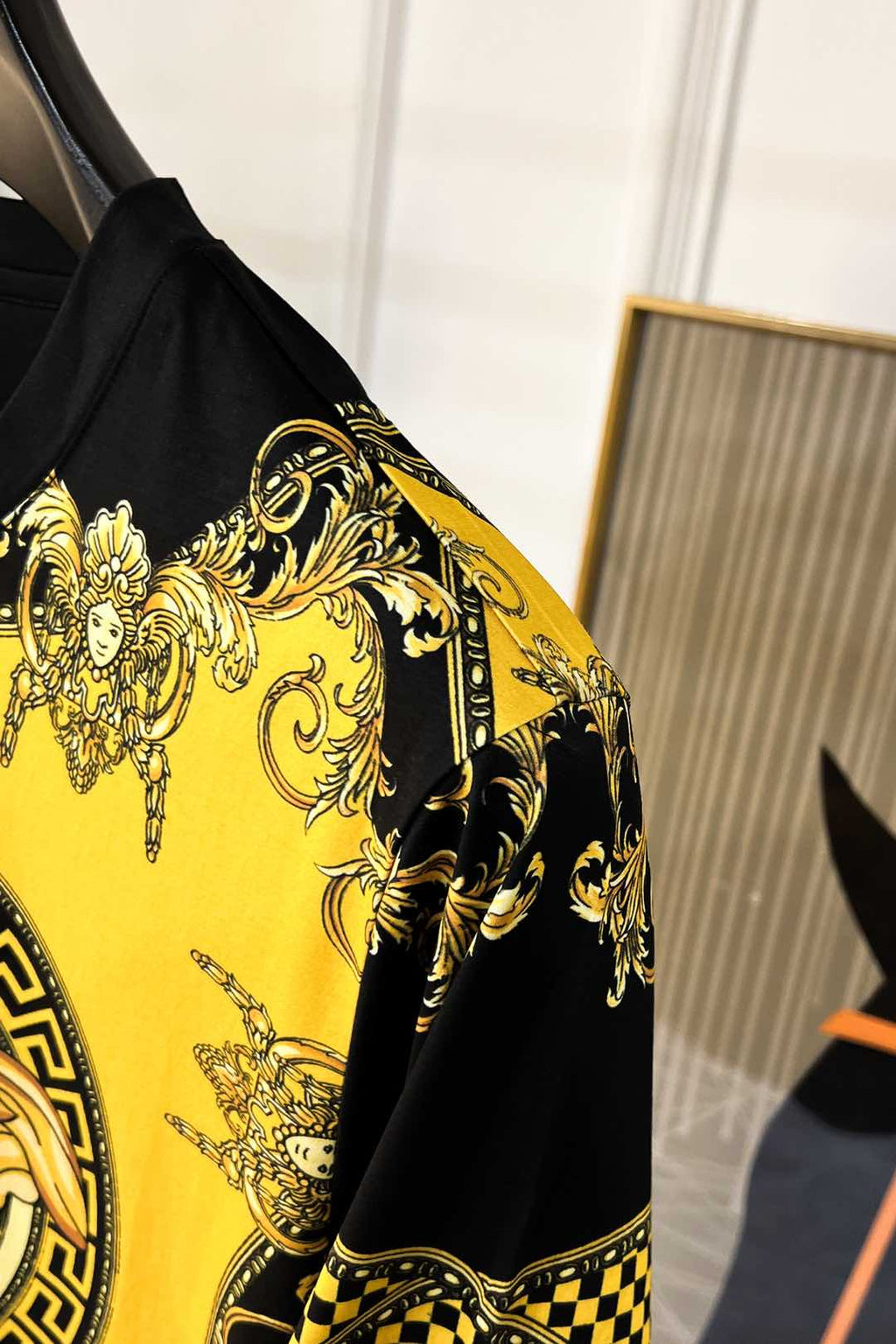 Graphic T-shirt sleeve and shoulder with gold baroque ornament on yellow and black