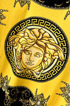 Graphic T-shirt close-up of gold Medusa-style face in black Greek key border
