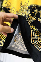 Graphic T-shirt hem and neckline seam detail in black with gold print trim