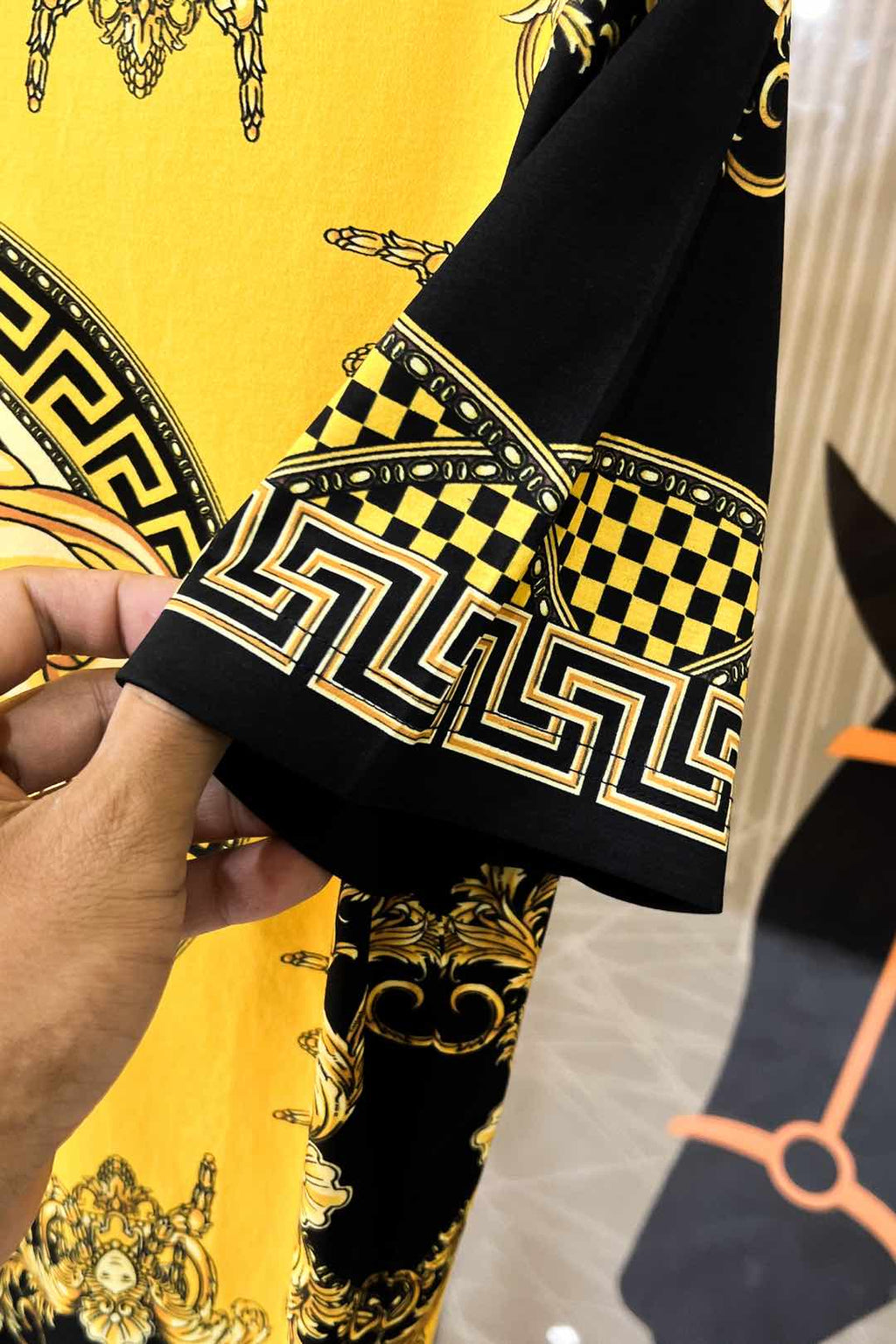 Graphic T-shirt sleeve cuff with black-and-gold trim and checkerboard pattern