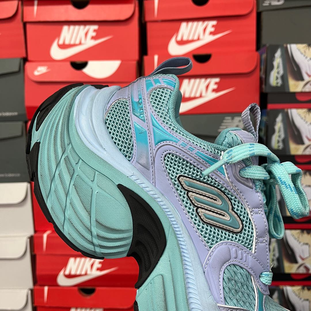 Teal athletic sneaker with lavender overlays, mesh panels, and turquoise laces