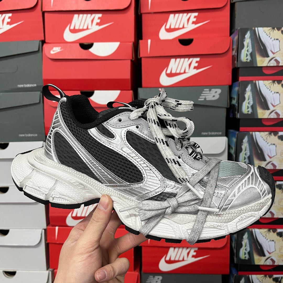 Chunky lace-up running shoes with black and silver uppers, white midsole and tread