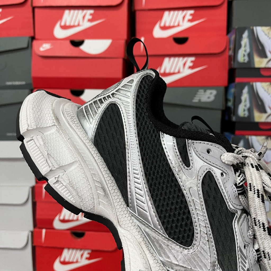 Lace-up sneakers with black heel collar, silver upper, and thick white cushioning sole
