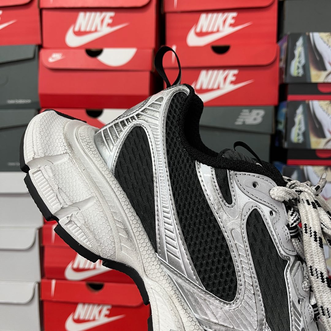 Lace-up sneakers with black heel collar, silver upper, and thick white cushioning sole