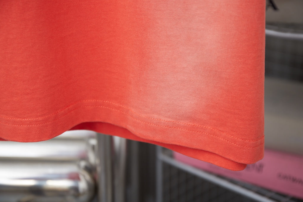 Coral orange short-sleeve T-shirt hem and stitching detail