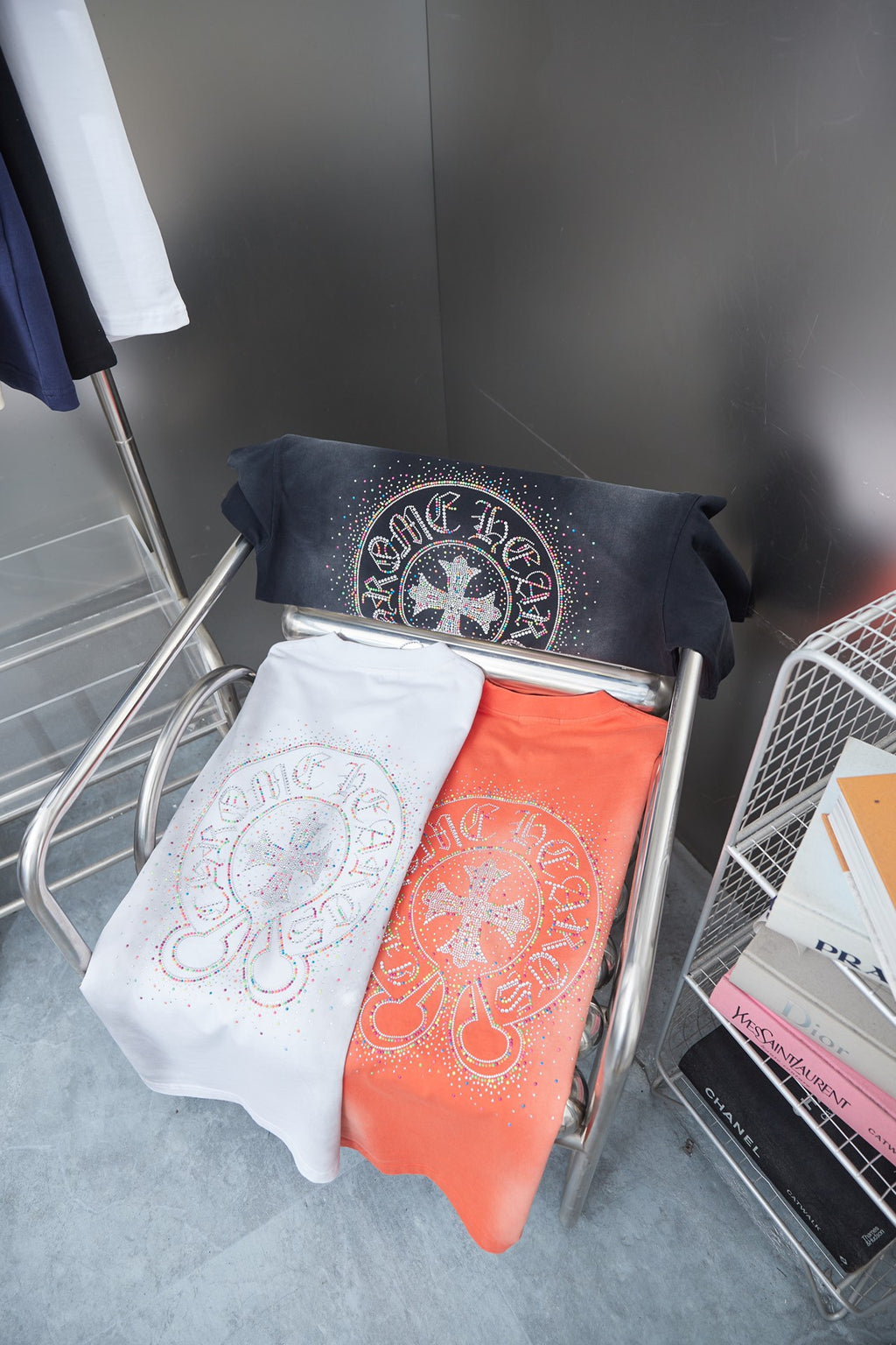 Folded white short-sleeve T-shirt with circular multicolor beaded graphic on rack