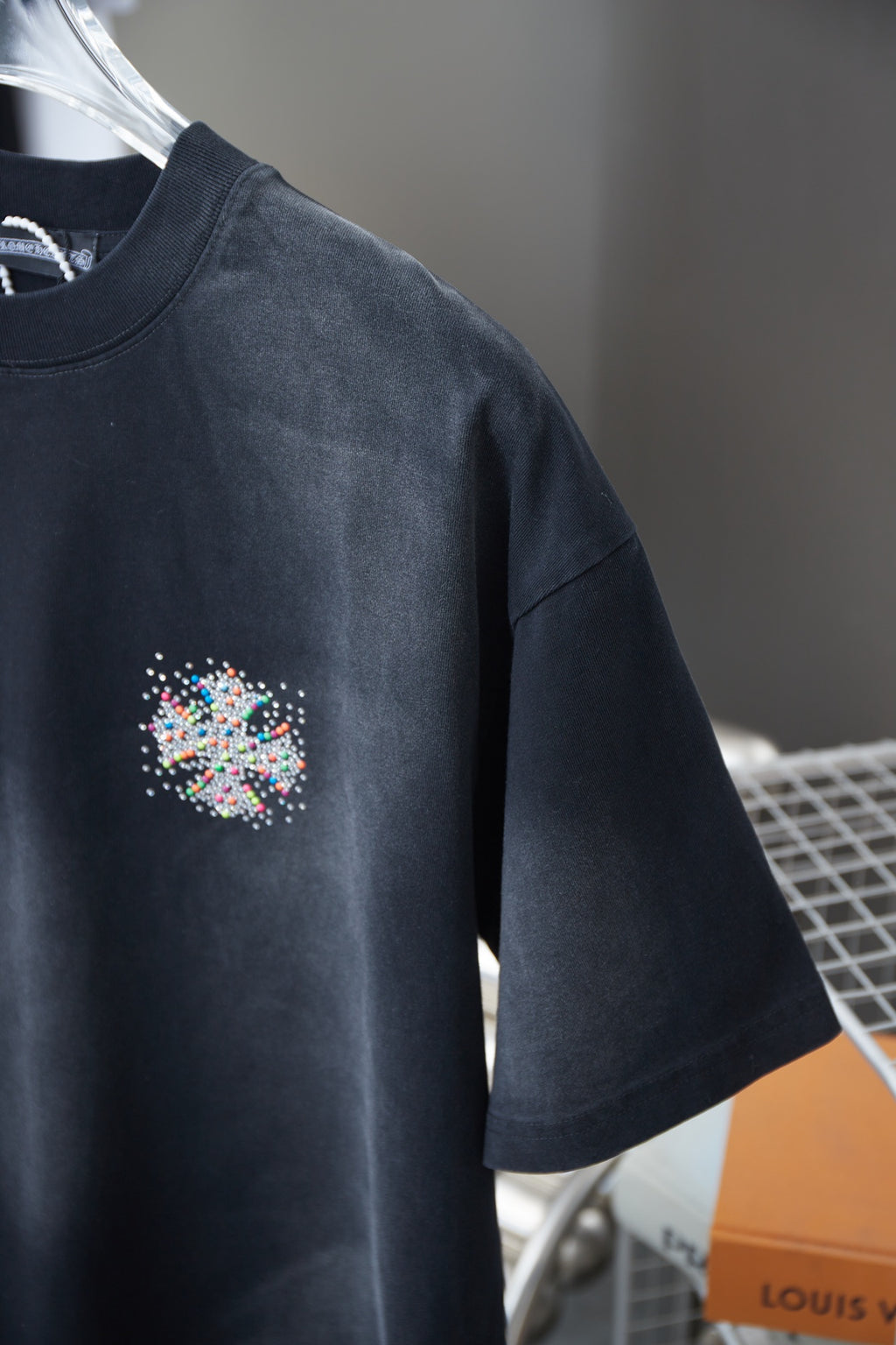 Navy short-sleeve T-shirt with small multicolor rhinestone chest emblem, side view