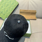Gucci cap top view with dark GG monogram fabric and metal button