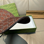 Brown Gucci baseball cap brim with black trim, GG-style monogram pattern.